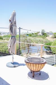 a chair and a table on a balcony at Red Bishop - Birds, Beach & Beauty in Langebaan