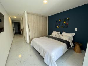 1 dormitorio con 1 cama grande y pared azul en LOFT excelente ubicación norte de Armenia, en Armenia