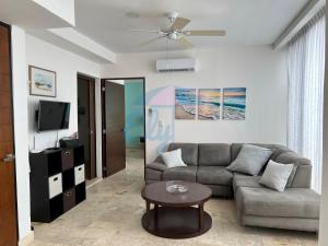 een woonkamer met een bank en een tafel bij Anah Downtown luxury condo in Playa del Carmen