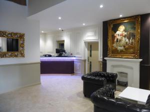 a living room with a fireplace and a painting on the wall at Dreams Hotel in Barking