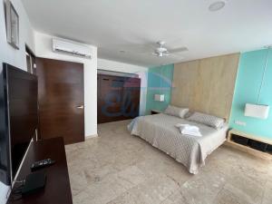 a bedroom with a bed and a flat screen tv at Anah Downtown luxury condo in Playa del Carmen