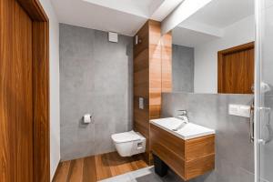 La salle de bains est pourvue d'un lavabo et de toilettes. dans l'établissement Rezydencja, 