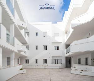 um grande edifício branco com um sinal que diz em Casa Alcoba de la luz em Sanlúcar de Barrameda