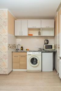 a kitchen with a washing machine and a microwave at 1 комнатная квартира по улице Предславинская, 12 in Kyiv