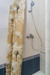 a shower curtain with flowers on it in a bathroom at 1 комнатная квартира по улице Предславинская, 12 in Kyiv