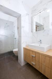 a white bathroom with a sink and a toilet at Marko’s apartment 