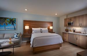 a bedroom with a large bed and a kitchen at The Pointe Hotel in Jupiter