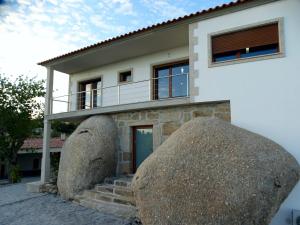 a house with two large rocks in front of it at Quinta do Cadaval 