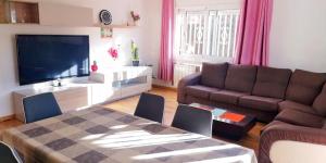 a living room with a television and a couch and a table at La Casa de Vacaciones in Terrassa