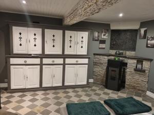 cocina con armarios blancos y suelo a cuadros en Maison typique privée - Sart Lez Spa - PINE COTTAGE- charme piscine, en Sart