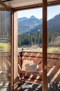 a glass door to a balcony with a view of the mountains at TATRA REST in Kościelisko