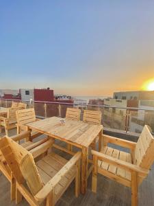 a wooden table and chairs on top of a roof at Ayour Beach House 5 in Imsouane