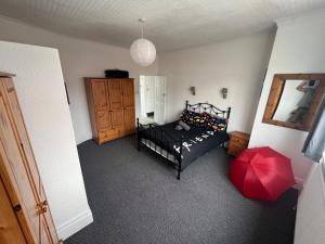 een slaapkamer met een zwart bed en een rode paraplu bij Friends House, Hot Tub, Sleeps 6 in Blackpool