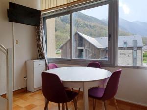 a room with a table and chairs and a large window at Moudang 11 in Saint-Lary-Soulan