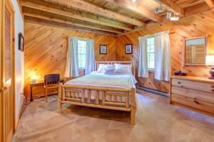 - une chambre avec un lit dans une pièce en bois dans l'établissement Rustic Roost Cabin, à Vega