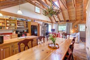 Il comprend une cuisine et une salle à manger avec une table et des chaises en bois. dans l'établissement Rustic Roost Cabin, à Vega