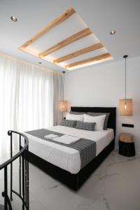 a bedroom with a large bed with white walls at Naxos Black Concept Maisonette in Naxos Chora
