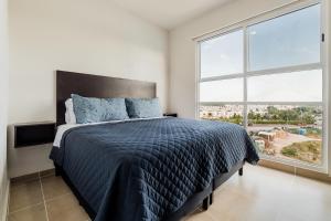 1 dormitorio con cama y ventana grande en Dream lagoons departamento en Cancún. en Cancún