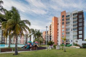 un parque con parque infantil frente a algunos edificios en Dream lagoons departamento en Cancún. en Cancún