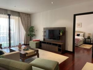a living room with a couch and a television at Anantara Luxury Hotel Apartment & Residences conected Anantara Hotel in Dubai