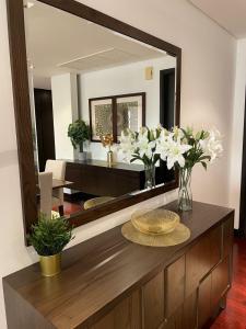 a living room with a mirror and a table with flowers at Anantara Luxury Hotel Apartment & Residences conected Anantara Hotel in Dubai