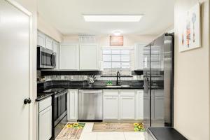 eine Küche mit weißen Schränken und einem Kühlschrank in der Unterkunft Saints Haven in Houston
