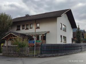 une maison blanche avec une clôture devant dans l'établissement Angi's Apartment, à Sankt Lorenzen ob Murau 7 autres photos