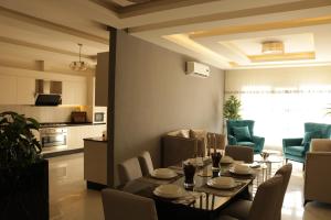 a dining room and living room with a table and chairs at Ritala Royal Residence in Amman