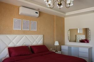 a bedroom with a red bed and a mirror at Ritala Royal Residence in Amman +33 photos
