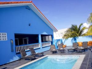 a blue building with chairs and a swimming pool at Casa Bonaventura in Kunuku Abou