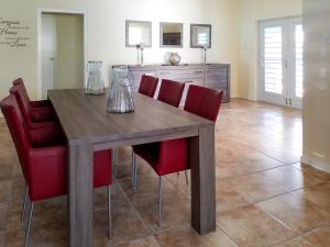 a wooden table with red chairs in a kitchen at Casa Bonaventura in Kunuku Abou