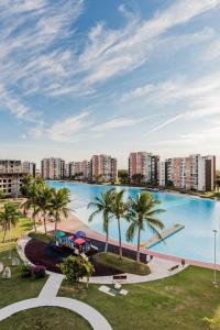 una gran piscina con palmeras y edificios en Dream lagoons departamento en Cancún. en Cancún