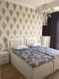 a bedroom with a white bed and a wall at Central City in Kutaisi