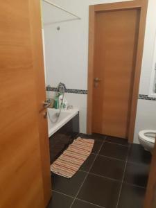 a bathroom with a sink and a toilet and a door at Adorable 3 bedroom Brenner "Hill" suite in Giv‘at Brenner