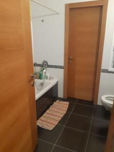 La salle de bains est pourvue d'un lavabo, de toilettes et d'une porte. dans l'établissement Adorable 3 bedroom Brenner "Hill" suite, à Giv‘at Brenner