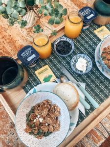 una mesa con un plato de comida y zumo de naranja en Malibu Hostal Boutique, en Maitencillo