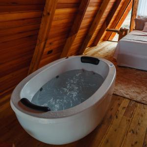 bañera en una habitación con suelo de madera en Cabana Vale do Funil, en Taió