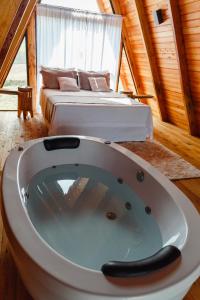 1 cama y bañera en una habitación en Cabana Vale do Funil, en Taió