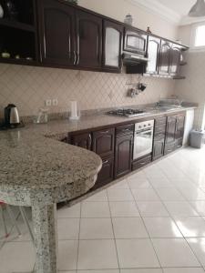 uma cozinha com armários de madeira e uma bancada de mármore em luxury villa em Agadir