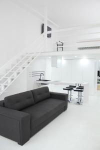 a living room with a black couch in front of a staircase at Luxury Apartments in Odesa