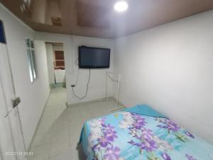 a bedroom with a bed and a tv on a wall at Apartamento independiente para pareja con cocina in Villavicencio