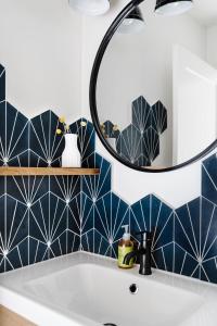 uma casa de banho com paredes em azulejos azuis e brancos e um lavatório. em Mount Rundle Hideaway with Heated Pool & Hot Tub and allows Pets em Canmore