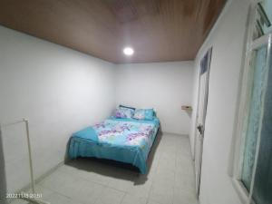 a small bedroom with a bed in a white room at Apartamento independiente para pareja in Villavicencio