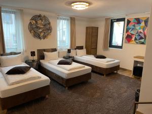 um quarto com três camas num quarto em A&C Hotel em Backnang