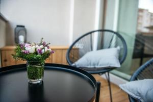 eine Glasvase mit Blumen auf einem Tisch in der Unterkunft Sunny home with cute dragon in the center+parking in Ljubljana