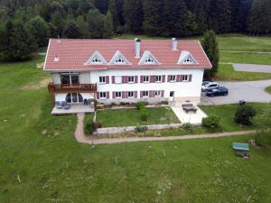 uma grande casa branca com um telhado vermelho em La Ferme Du Levant em Gérardmer