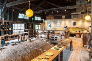 una grande cucina con tavoli in legno in una stanza di 朝ドラのロケ地 信楽焼きの窯元に泊まれます 無料駐車場有 4人まで宿泊可能 a Nagano