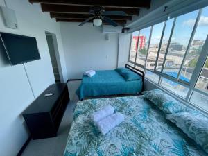 a bedroom with two beds and a flat screen tv at Exclusivo apartamento Duplex Bahia fragata in San Andrés