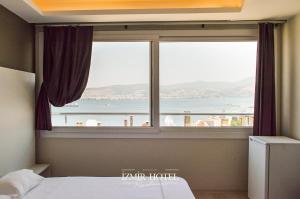 1 dormitorio con ventana y vistas al océano en BRAGEÇAM REZİDANS OTEL en Konak