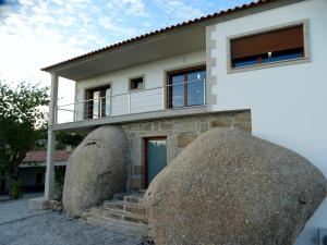 a house with two large rocks in front of it at Quinta do Cadaval in Cortiçô